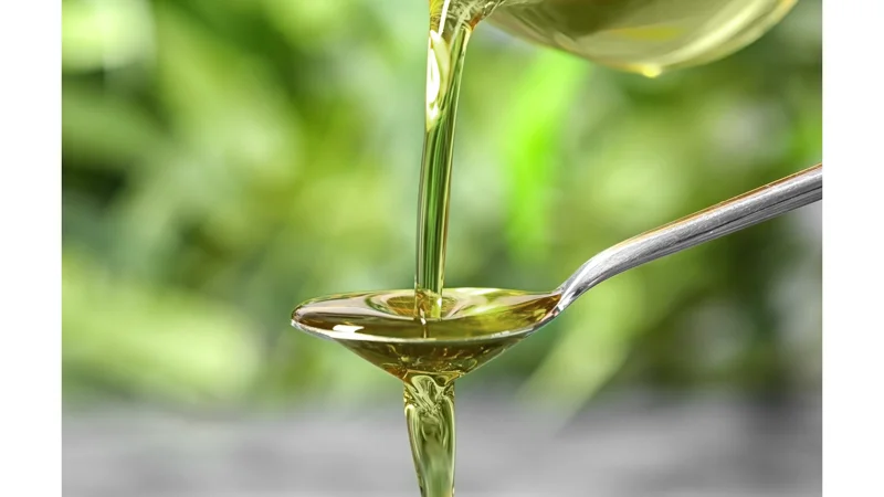 CBD Oil Poured in a Spoon in a Blurry Background