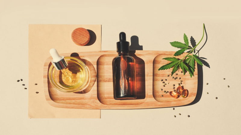 CBD Oil in the Wooden Tray with Hemp Leaves 