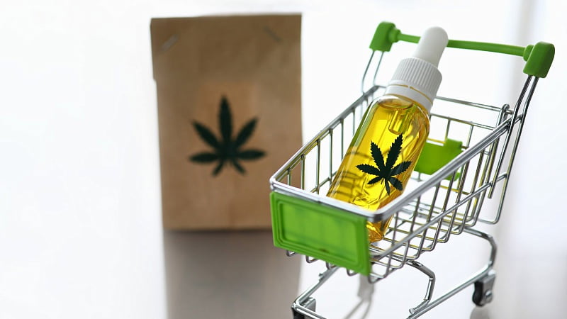 CBD oil on a shopping cart and a paper bag with hemp leaf logo
