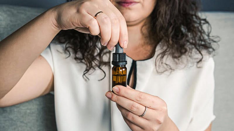 a woman holding CBD Oil bottle