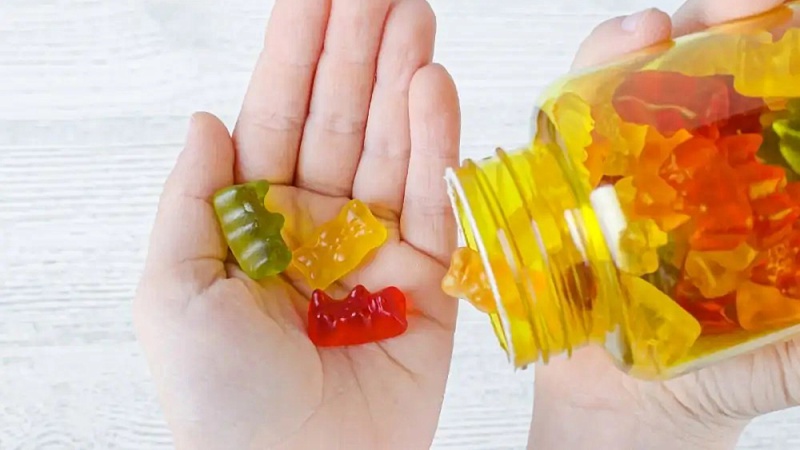 a hand getting D8 THC gummies from a container