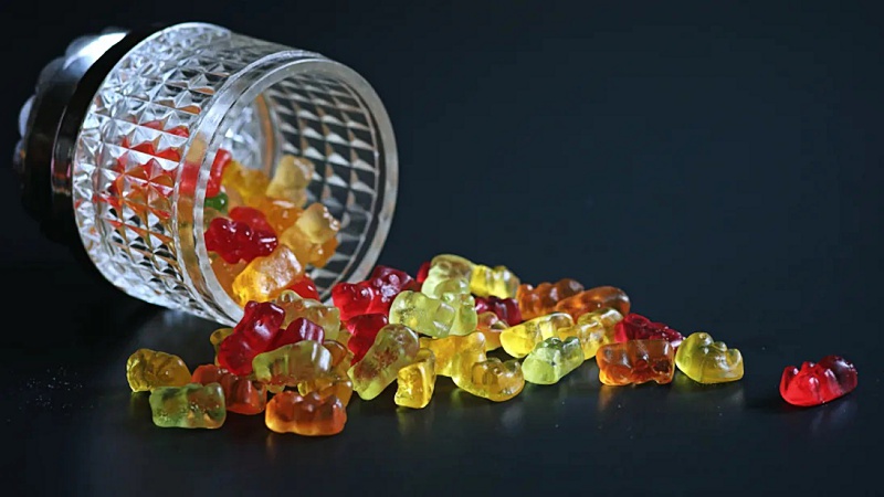 multicolored THC gummies in a bowl on a black background