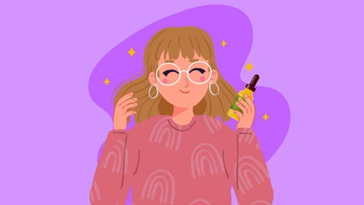 a woman holding a bottle of CBD oil