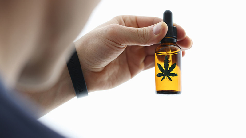 Man Holding CBD Oil Bottle