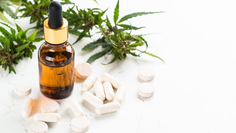 CBD Oil Bottle and Pills with Hemp Leaves