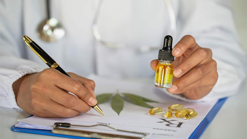 Doctor Holding CBD/CBC Oil with Pen and Prescription Paper
