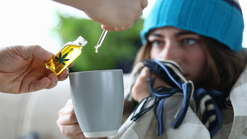 lady with cold taking drink with cbd oil