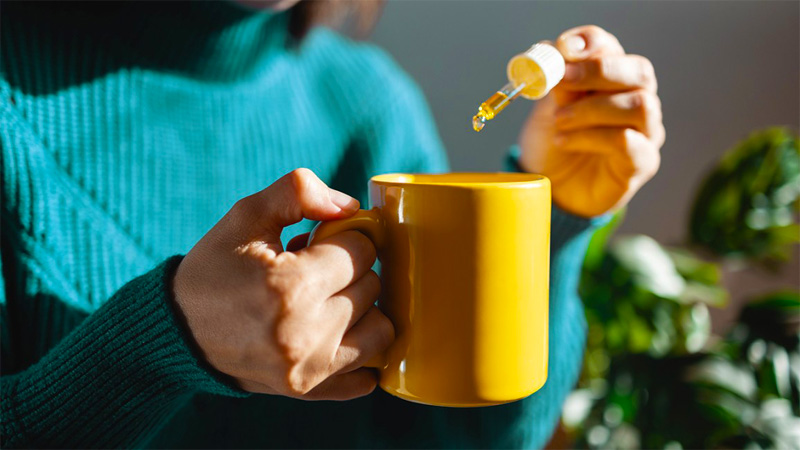 Woman using CBD oil on a cup