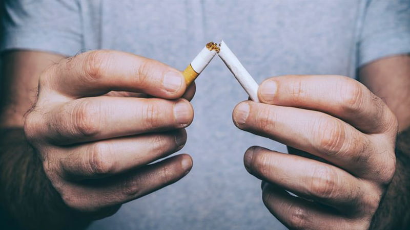 Man breaking a cigarette in half