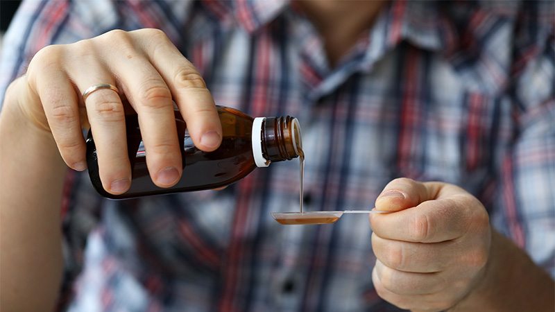 Image of guy Pouring CBD Oil on a Spoon