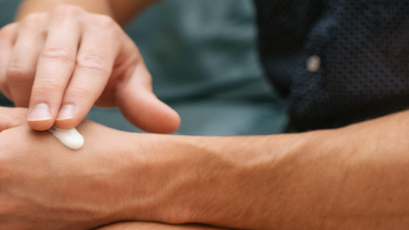 Image of hand applying CBD cream on painful wrist