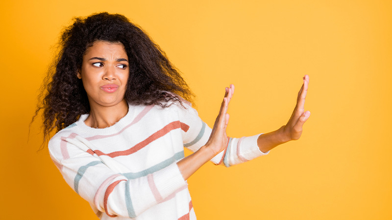 Woman trying to avoid something by putting by blocking her hands