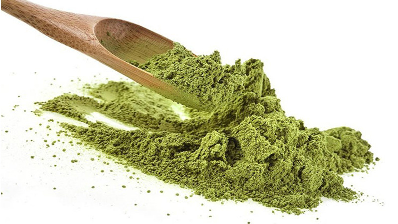 Kratom powder with a wooden teaspoon to measure dosage