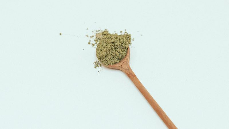 Image of kratom powder and wooden spoon