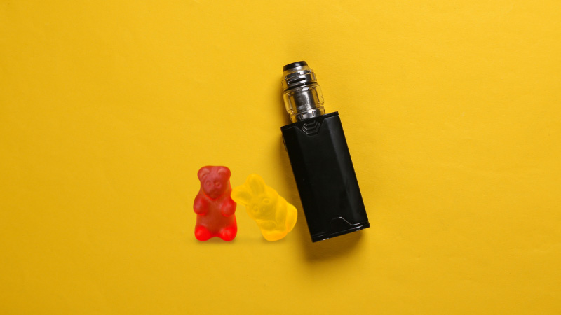 Delta-8 THC gummies and vape in yellow background.