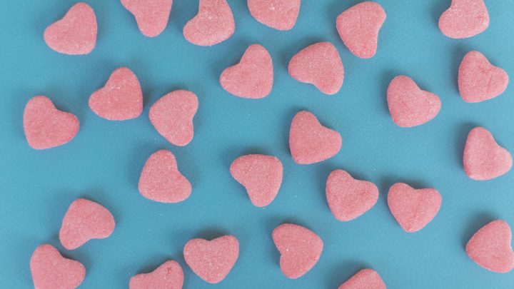 Heart-shaped CBD gummies for erectile dysfunction on blue background