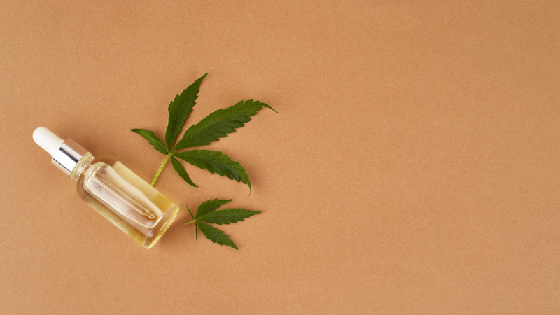 Delta_8 THC tincture with hemp leaves on a light brown background
