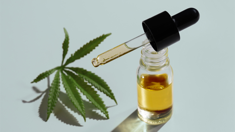 HHC oil bottle and a cannabis leaf